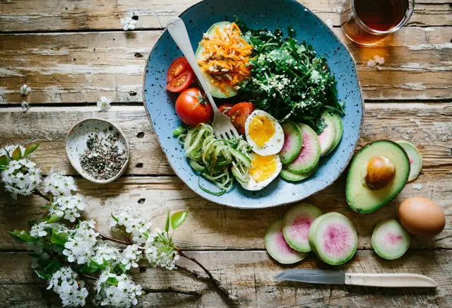 A plate of eggs, avocado and vegetables