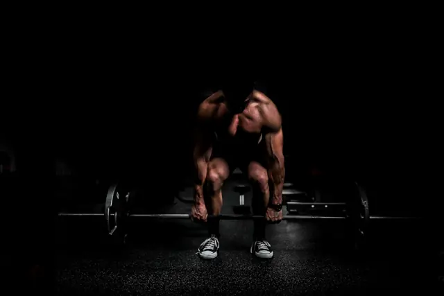 Athlete gripping a loaded barbell before a deadlift